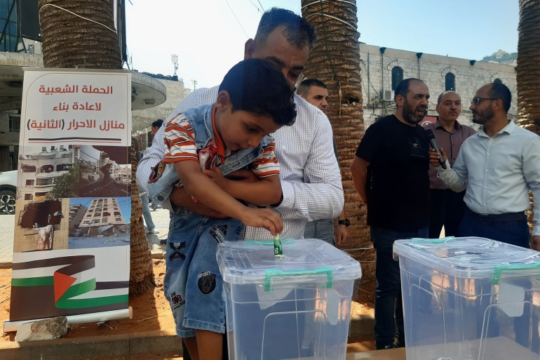 عاطف دغلس- طفل يقوم بالتبرع خلال اطلاق الحملة- الضفة الغربية- نابلس- وسط المدينة- الجزيرة نت4