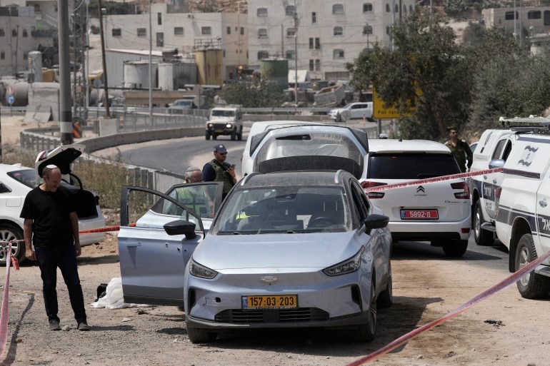 Israeli forces and Zaka Rescue and Recovery team members work at the site of a shooting attack near the West Bank city of Hebron, Monday, Aug. 21, 2023. Israeli authorities say that a suspected Palestinian attacker has killed an Israeli woman and seriously wounded a man in the incident. (AP Photo/Mahmoud Illean)