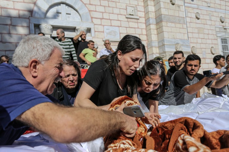 People sheltering at the Saint Porphyrius Orthodox church which was hit by an Israeli airstrike on Thursday, killing 18 including several children [Abdelhakim Abu Riash/Al Jazeera]