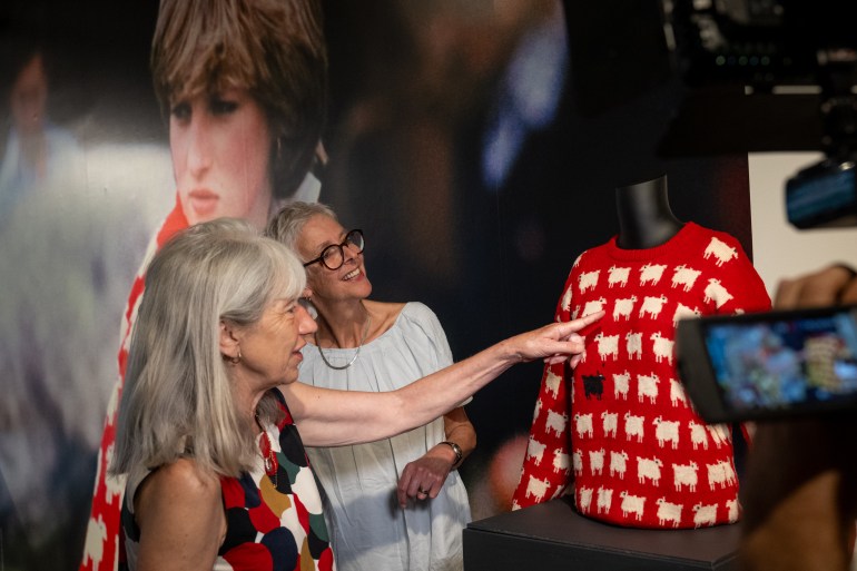 NEW YORK, NEW YORK - SEPTEMBER 07: Designers Sally Muir and Joanna Osborne pose with their Black Sheep Sweater worn by Lady Diana Spencer on the first day it is displayed at Sotheby's on September 07, 2023 in New York City. The sweater was originally worn when Lady Diana Spencer attended one of Prince Charles’ summer polo matches, donning the red sweater designed by Sally Muir and Joanna Osborne for their knitwear label, Warm & Wonderful. It was later damaged, and a letter was sent to the designers from Princess Diana’s private secretary, Oliver Everett CVO, requesting it be fixed or replaced. Muir and Osborne knitted a new one, when the second letter was received. The sweater is appearing at auction for the first time ever, with a week in London before a week in New York. It is expected to be auctioned for $50,000 -$80,000 (£40,000 – 70,000). (Photo by Alexi Rosenfeld/Getty Images)