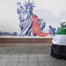 إيرانية تلتف بالعلم الفلسطيني وتجلس أمام رسم معادٍ لأميركا على حائط سفارتها السابقة في طهران 4 نوفمبر الجاري (رويترز)