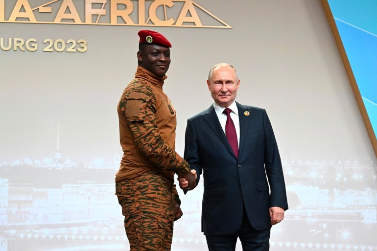 This pool image distributed by Sputnik agency shows Russian President Vladimir Putin greeting Burkina Faso's junta leader Captain Ibrahim Traore during a welcoming ceremony at the second Russia-Africa summit in Saint Petersburg on July 27, 2023. (Photo by Pavel BEDNYAKOV / POOL / AFP)