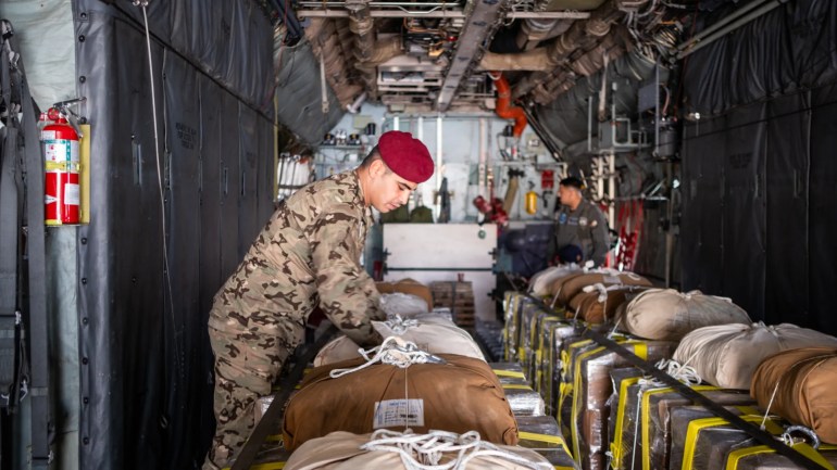 A member of the Jordanian Special Forces checks the parachutes ahead of takeoff [Nils Adler/Al Jazeera]