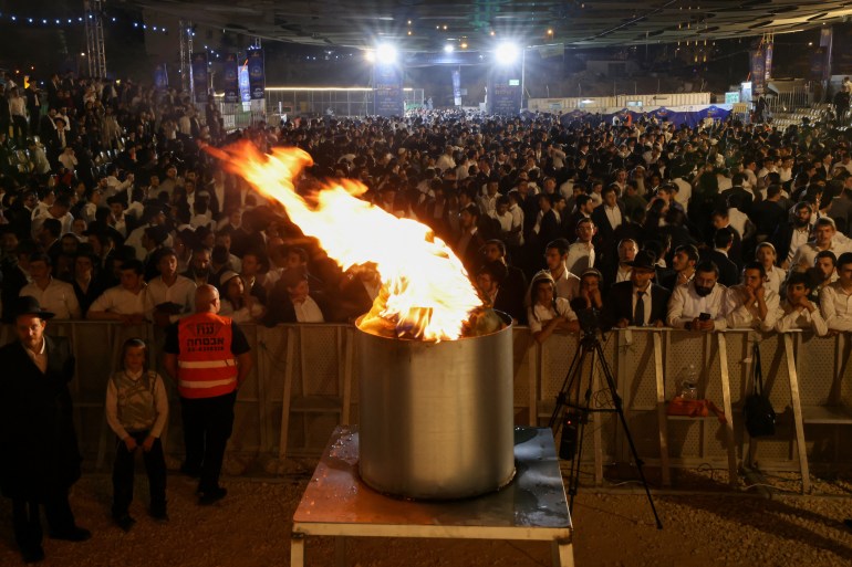 Ultra-Orthodox Jewish men watch a fire burn as they celebrate the Jewish holiday of Lag BaOmer in the Sheikh Jarrah neighbourhood of Israeli-annexed east Jerusalem on May 25, 2024. - Lag BaOmer marks the anniversary of the death of Talmudic sage Rabbi Shimon Bar Yochai approximately 1,900 years ago. (Photo by AHMAD GHARABLI / AFP)