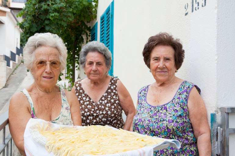 Older women with basket of pasta - stock photo