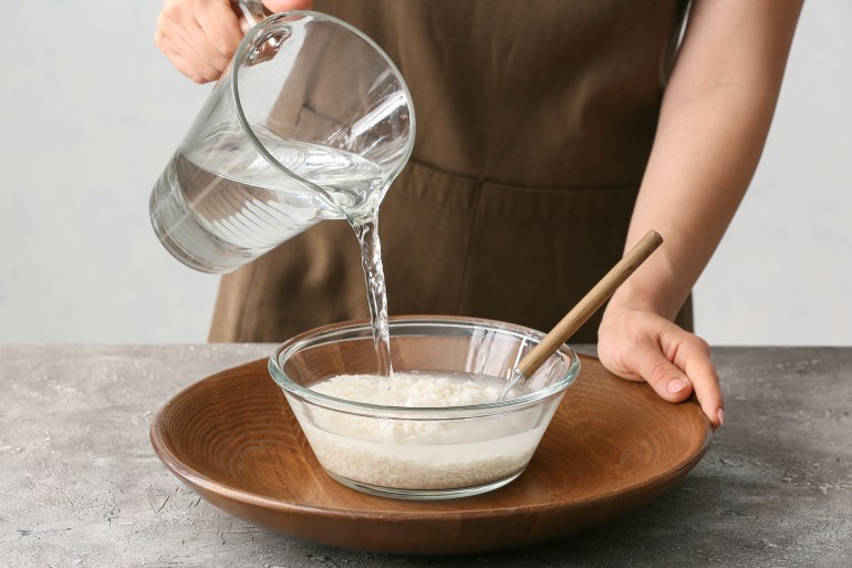 Woman preparing rice water on table; Shutterstock ID 2065937777; purchase_order: aj net; job: ; client: ; other: