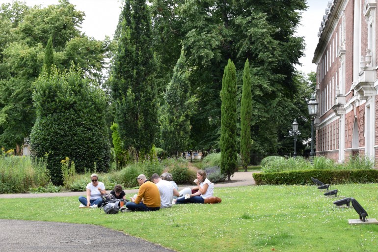 **داخلية** London, UK - Jul 15, 2024: Students and their parents check smartphones on the campus lawn شترستوك