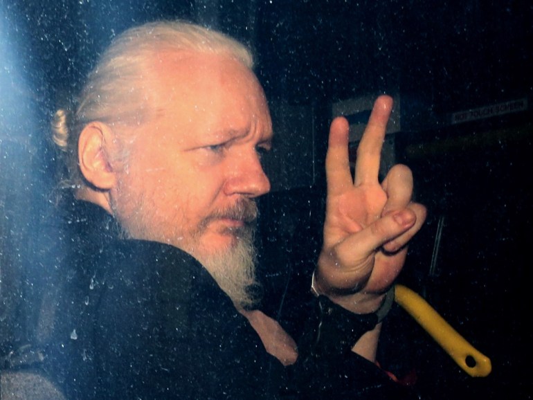 LONDON, ENGLAND - APRIL 11: Julian Assange gestures to the media from a police vehicle on his arrival at Westminster Magistrates court on April 11, 2019 in London, England. After weeks of speculation Wikileaks founder Julian Assange was arrested by Scotland Yard Police Officers inside the Ecuadorian Embassy in Central London this morning. Ecuador's President, Lenin Moreno, withdrew Assange's Asylum after seven years citing repeated violations to international conventions. (Photo by Jack Taylor/Getty Images)