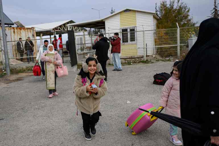 Syrians living in Turkey arrive with their belongings at the Oncupinar border crossing to enter Syria, in Kilis on December 11, 2024. Turkey has expanded its border crossing capacities to accommodate the surge in Syrian refugees seeking to return home following the fall of president Bashar al-Assad. (Photo by Yasin AKGUL / AFP)