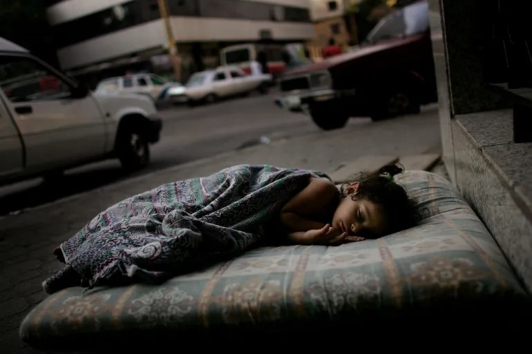 Three-year-old Doua Nabou sleeps on a street corner while her family decides where to evacuate in anticipation of Israeli air strikes on August 10, 2006 [Spencer Platt/Getty Images]