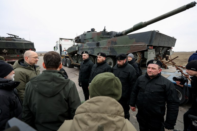 Ukrainian PM Shmyhal and Polish PM Morawiecki speak to Polish service members next to the first Leopard 2 tanks delivered from Poland, in an undisclosed location in Ukraine