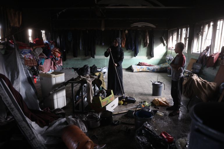 A Palestinian woman sweeps the floor inside a classroom after an Israeli airstrike hit the Mussa bin Nusseir UNRWA school, serving as a shelter for people who left their homes in the besieged Palestinian territory, in Gaza City's Daraj district on May 20, 2025.
