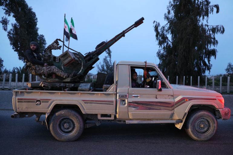SYRIA - MARCH 7: A fighter with the new Syrian government rides in a truck mounted with an anti-aircraft gun on March 7, 2025 on the road between Homs and Tartus, Syria. Dozens of people have been killed in clashes between loyalists of the deposed Assad regime and forces of the country's new rulers. It is the heaviest such fighting since Syrian rebels toppled the Assad regime last December. (Photo by Ali Haj Suleiman/Getty Images)