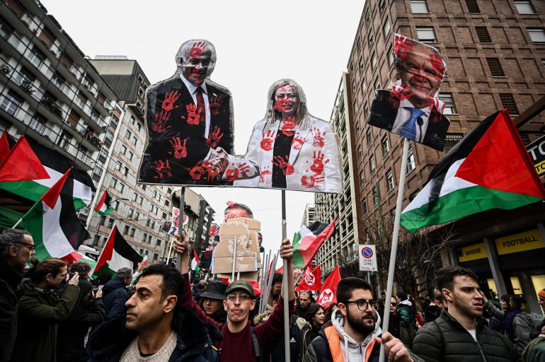 Demonstrators hold placards depicting Prime Minister of Israel Benjamin Netanyahu shaking hands with Prime Minister of Italy Giorgia Meloni during a protest in support of Palestinians and to demand an immediate ceasefire in the Gaza strip, on February 24, 2024 in Milan. - Overall, at least 29,606 people have been killed in Gaza amid the ongoing conflict between Israel and the Palestinian militant group Hamas. The UN humanitarian agency OCHA warned that "the elevated risk of famine in Gaza is projected to increase" without enough food and water, as well as health services. (Photo by Piero CRUCIATTI / AFP)